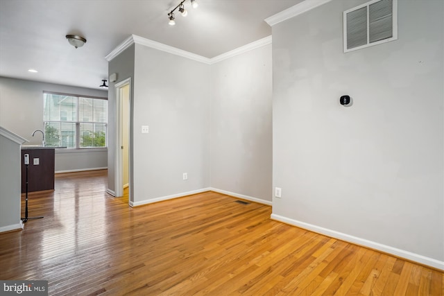 16758 Blackjack Oak Ln, Woodbridge, VA 22191 - empty room featuring baseboards, wood finished floors, crown molding, rail lighting, and a sink
