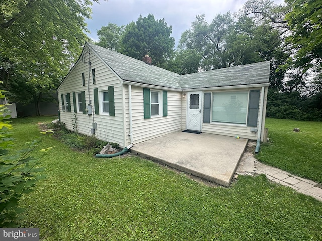 65 Rachel Ln, Inwood, WV 25428 - view of front of house featuring a patio area, a front yard, a chimney, and roof with shingles