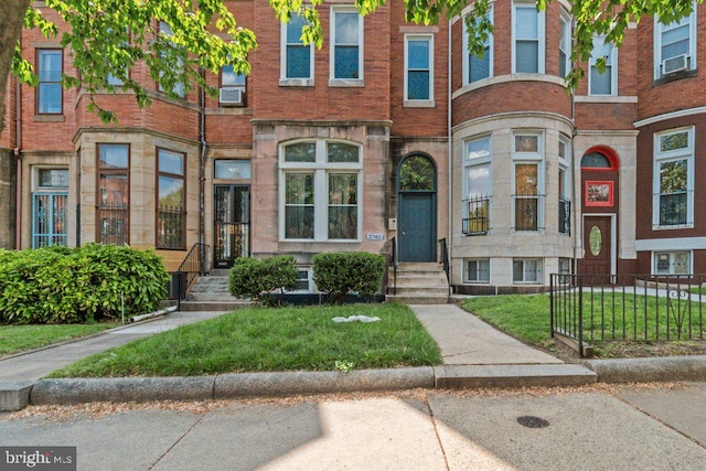 2740 Saint Paul St, Baltimore, MD 21218 - view of property with brick siding, cooling unit, entry steps, and a front lawn