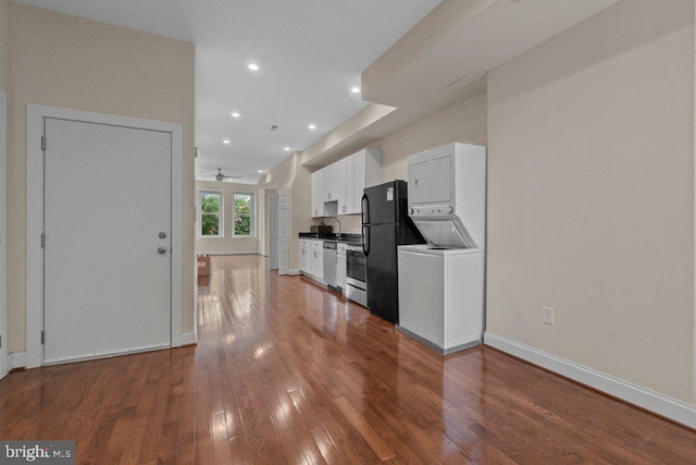 2740 Saint Paul St, Baltimore, MD 21218 - kitchen with stacked washing machine and dryer, appliances with stainless steel finishes, white cabinets, hardwood / wood-style flooring, and recessed lighting