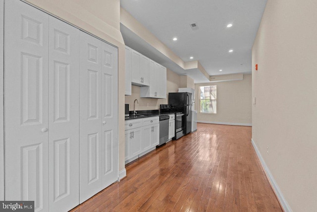 2740 Saint Paul St, Baltimore, MD 21218 - kitchen featuring a sink, stainless steel dishwasher, white cabinetry, hardwood / wood-style flooring, and recessed lighting
