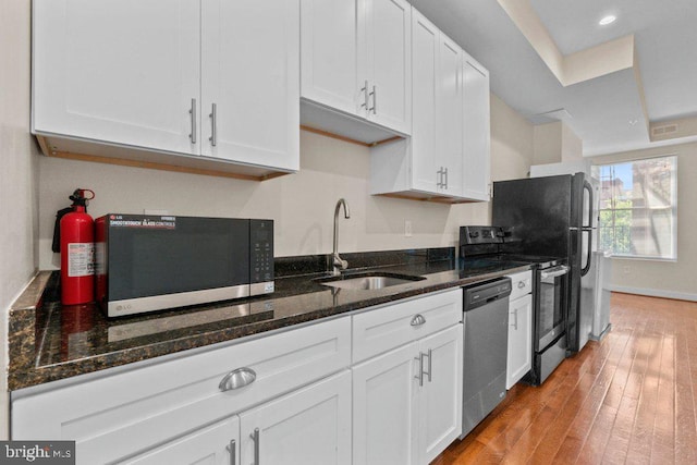 2740 Saint Paul St, Baltimore, MD 21218 - kitchen with black microwave, stainless steel dishwasher, white cabinets, a sink, and range