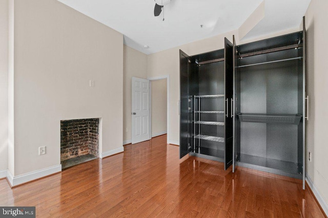 2740 Saint Paul St, Baltimore, MD 21218 - unfurnished bedroom with wood finished floors, baseboards, and a fireplace