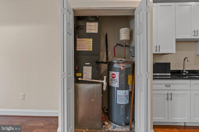 2740 Saint Paul St, Baltimore, MD 21218 - utility room featuring electric water heater, a sink, and heating unit