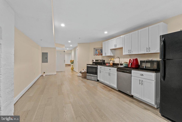 2740 Saint Paul St, Baltimore, MD 21218 - kitchen with black appliances, light wood-style flooring, recessed lighting, dark countertops, and white cabinetry