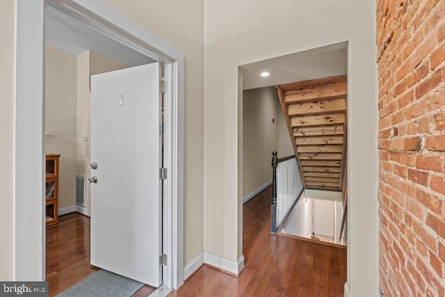 2740 Saint Paul St, Baltimore, MD 21218 - hall with an upstairs landing, wood finished floors, baseboards, brick wall, and recessed lighting