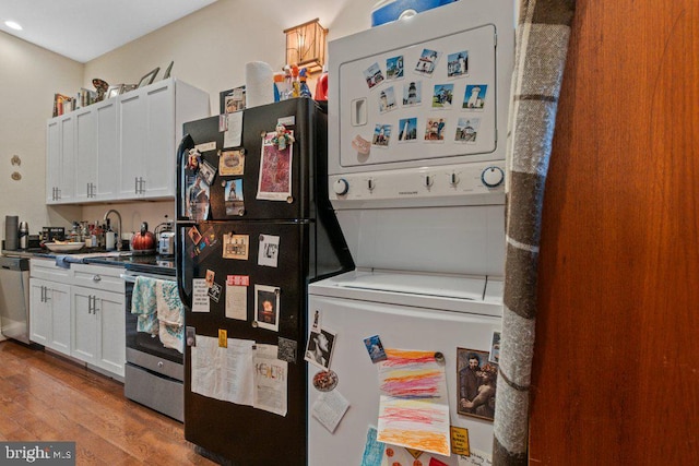 2740 Saint Paul St, Baltimore, MD 21218 - kitchen featuring estacked washer and dryer, stainless steel appliances, wood finished floors, white cabinets, and recessed lighting
