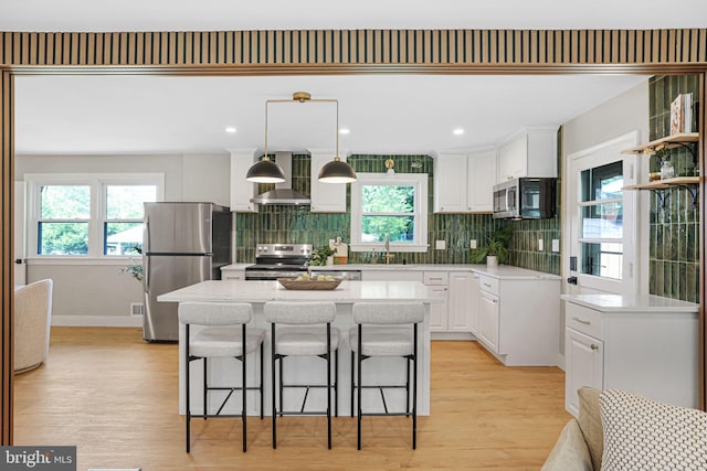 12300 La Plata St, Silver Spring, MD 20904 - kitchen with appliances with stainless steel finishes, wall chimney range hood, white cabinets, tasteful backsplash, and healthy amount of natural light