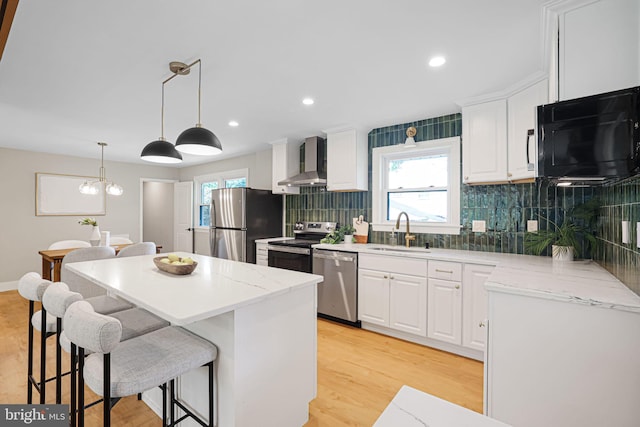 12300 La Plata St, Silver Spring, MD 20904 - kitchen featuring stainless steel appliances, a sink, wall chimney exhaust hood, a center island, and white cabinets