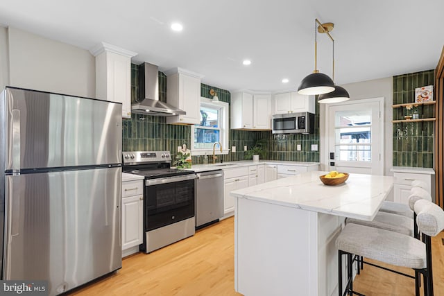 12300 La Plata St, Silver Spring, MD 20904 - kitchen with stainless steel appliances, wall chimney range hood, light wood finished floors, white cabinets, and recessed lighting