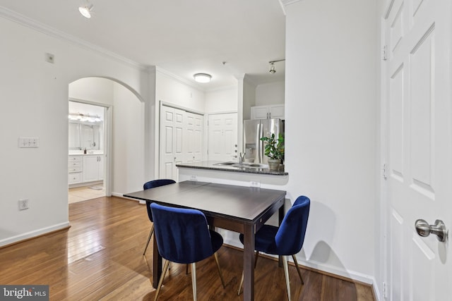 12925 Centre Park Cir Unit 106, Herndon, VA 20171 - dining space featuring arched walkways, wood finished floors, ornamental molding, and baseboards