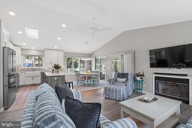 917 Lake View Dr, Bethany Beach, DE 19930 - living area with lofted ceiling, a glass covered fireplace, recessed lighting, light wood-style floors, and ceiling fan