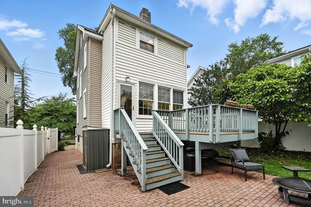 3921 22nd St NE, Washington, DC 20018 - rear view of property featuring a deck, a fenced backyard, a patio, a chimney, and a fire pit