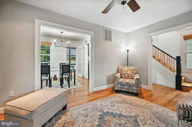 3921 22nd St NE, Washington, DC 20018 - living room featuring wood finished floors, a chandelier, stairs, and ceiling fan