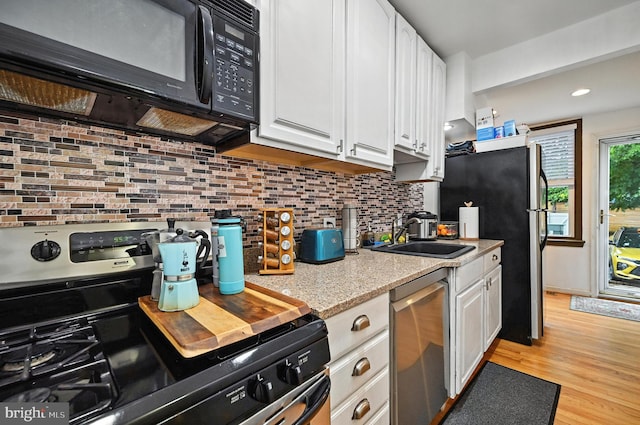 3921 22nd St NE, Washington, DC 20018 - kitchen featuring stainless steel appliances, white cabinets, tasteful backsplash, light wood finished floors, and recessed lighting