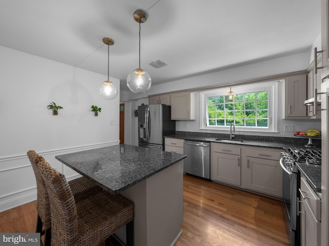 9103 Chickawane Ct, Alexandria, VA 22309 - kitchen with stainless steel appliances, a sink, gray cabinetry, a breakfast bar area, and a center island