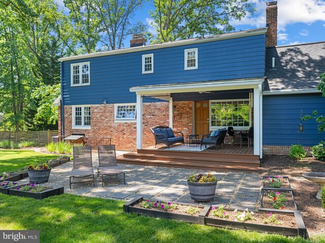 9103 Chickawane Ct, Alexandria, VA 22309 - rear view of property featuring a garden, a chimney, a deck, a patio, and brick siding
