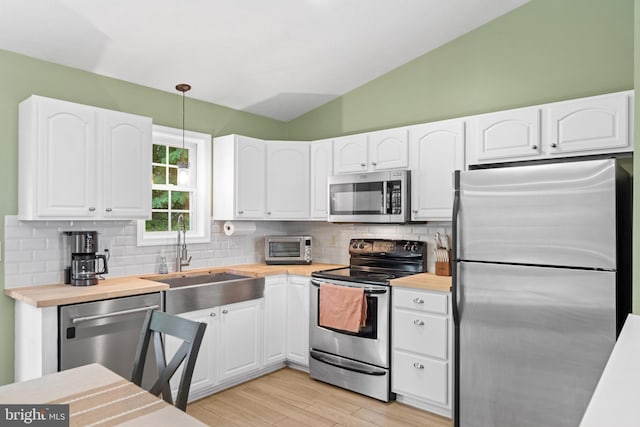 1971 High Top Rd, Linden, VA 22642 - kitchen with stainless steel appliances, butcher block countertops, tasteful backsplash, white cabinets, and vaulted ceiling