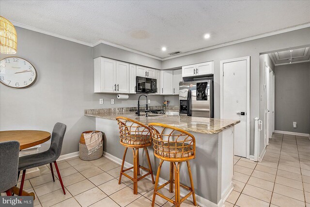 425 Robin Dr Unit 302, Ocean City, MD 21842 - kitchen featuring black microwave, stainless steel refrigerator with ice dispenser, light tile patterned flooring, a peninsula, and a breakfast bar