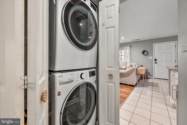 425 Robin Dr Unit 302, Ocean City, MD 21842 - laundry area with stacked washer / dryer, light tile patterned floors, and baseboards