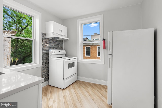 755 S 22nd St, Philadelphia, PA 19146 - kitchen with white appliances, under cabinet range hood, white cabinets, light countertops, and baseboards