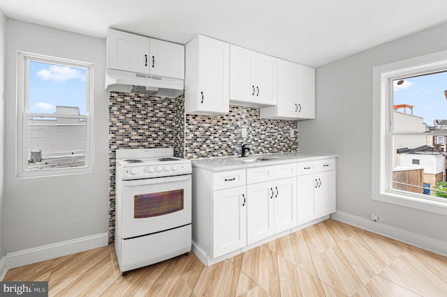 755 S 22nd St, Philadelphia, PA 19146 - kitchen featuring under cabinet range hood, white electric range oven, a sink, light countertops, and plenty of natural light