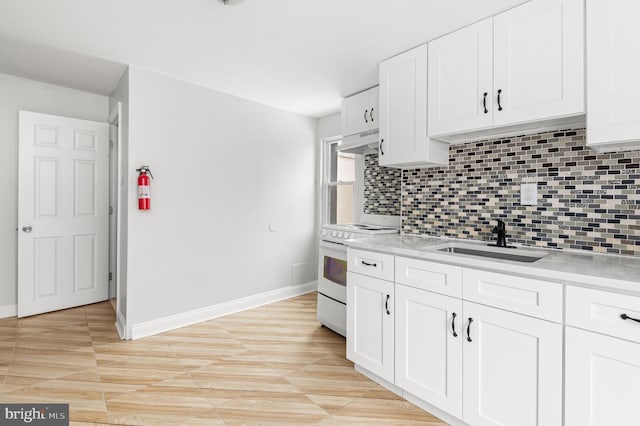 755 S 22nd St, Philadelphia, PA 19146 - kitchen with white range oven, a sink, under cabinet range hood, light countertops, and tasteful backsplash