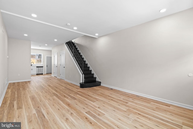 1728 S Bancroft St, Philadelphia, PA 19145 - unfurnished living room with light wood finished floors, baseboards, stairway, recessed lighting, and a sink