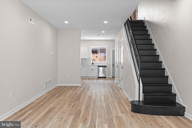 1728 S Bancroft St, Philadelphia, PA 19145 - unfurnished living room with a sink, stairs, light wood-style floors, recessed lighting, and baseboards