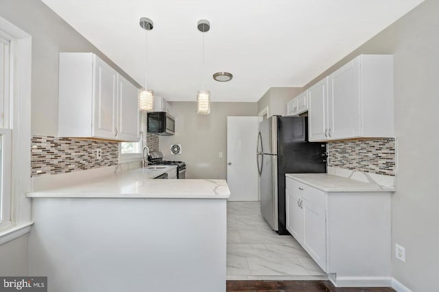1203 Daniels Ave, Baltimore, MD 21207 - kitchen with appliances with stainless steel finishes, white cabinets, backsplash, and light marble finish floors