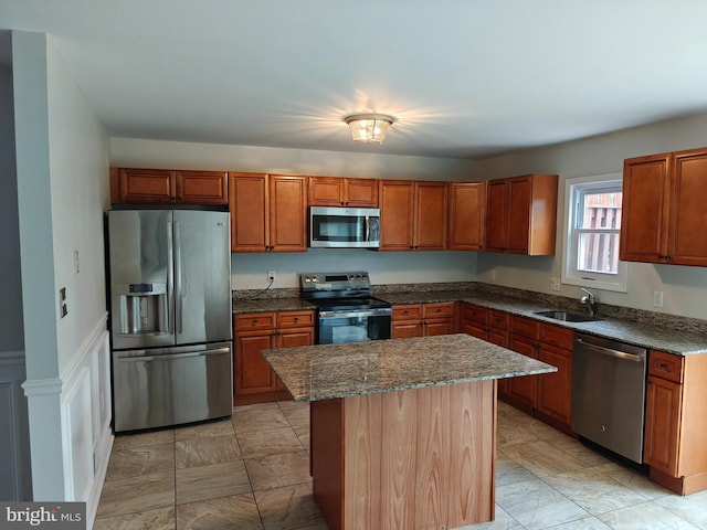 3910 Gatehouse Ln, Skippack, PA 19474 - kitchen featuring stainless steel appliances, a sink, a kitchen island, dark stone countertops, and brown cabinets