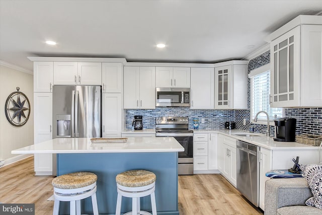 6801 Atlantic Ave Unit 2, Ocean City, MD 21842 - kitchen with stainless steel appliances, a sink, a breakfast bar area, crown molding, and light wood-type flooring