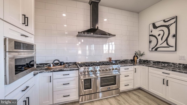 21 Hart Ln, Ventnor City, NJ 08406 - kitchen featuring wall chimney exhaust hood, stainless steel appliances, dark stone countertops, and backsplash