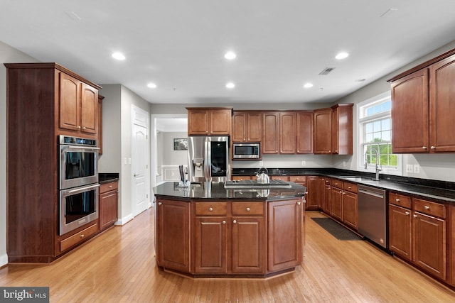 8800 Primula Dr, Laytonsville, MD 20882 - kitchen with appliances with stainless steel finishes, a sink, light wood-type flooring, a kitchen island, and recessed lighting