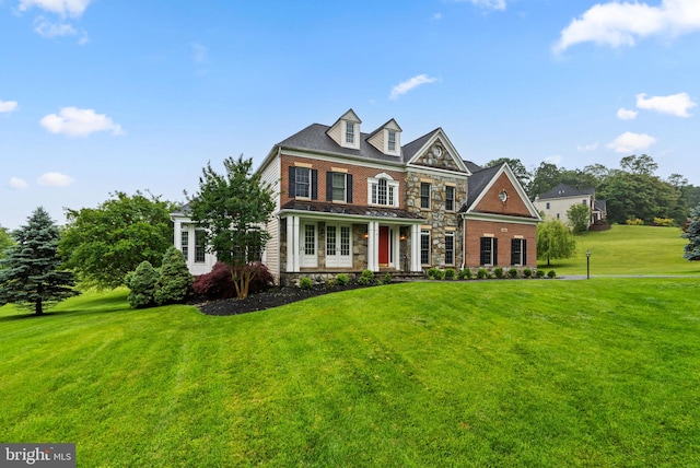 8800 Primula Dr, Laytonsville, MD 20882 - georgian-style home featuring stone siding, a front lawn, a standing seam roof, and brick siding
