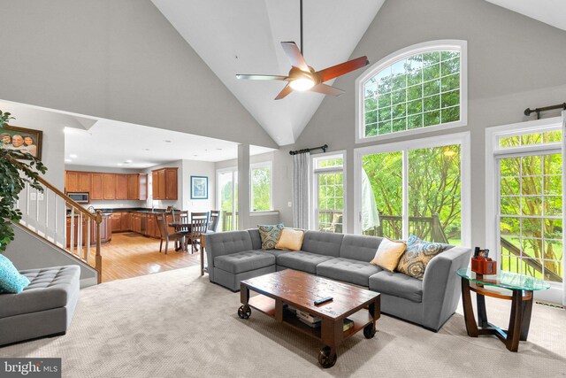 8800 Primula Dr, Laytonsville, MD 20882 - living area featuring ceiling fan, healthy amount of natural light, high vaulted ceiling, light carpet, and stairway