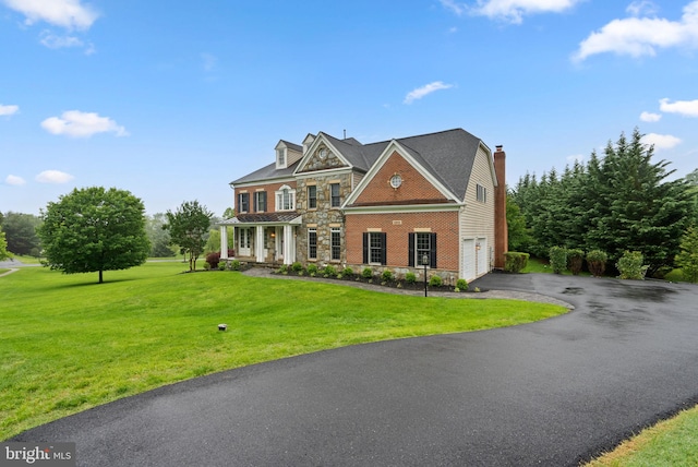 8800 Primula Dr, Laytonsville, MD 20882 - georgian-style home with driveway, an attached garage, a front yard, stone siding, and a chimney