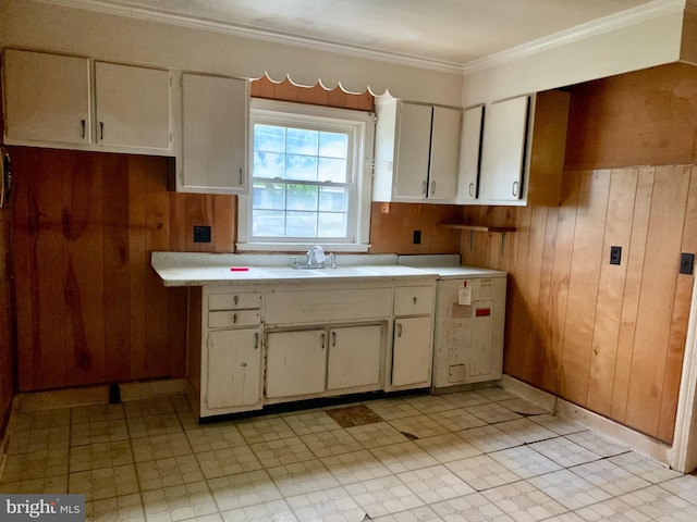 30536 Bennett Rd, Salisbury, MD 21804 - kitchen with a sink, wooden walls, light countertops, white cabinets, and ornamental molding
