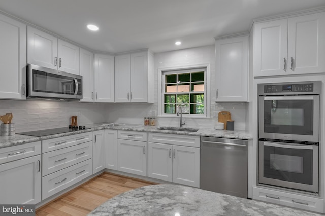1334 Elsinore Ave, Mclean, VA 22102 - kitchen with appliances with stainless steel finishes, a sink, tasteful backsplash, white cabinetry, and light wood-style floors