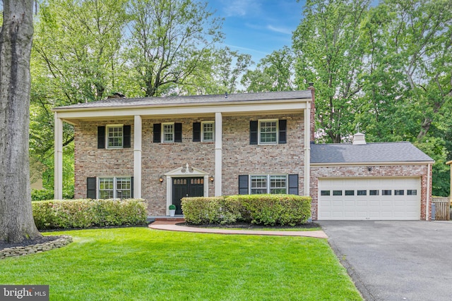 1334 Elsinore Ave, Mclean, VA 22102 - greek revival house featuring driveway, a front yard, a chimney, an attached garage, and brick siding