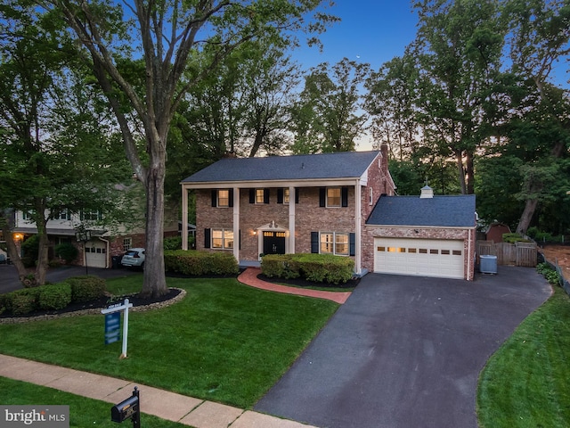 1334 Elsinore Ave, Mclean, VA 22102 - greek revival house with central AC unit, asphalt driveway, an attached garage, a chimney, and brick siding