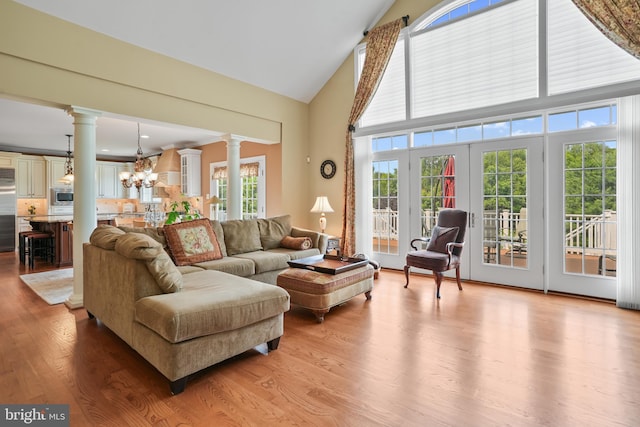 2860 Pfefferkorn Rd, West Friendship, MD 21794 - living room featuring decorative columns, a chandelier, high vaulted ceiling, and light wood-style floors