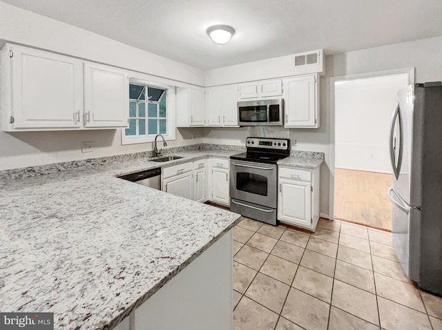 13109 Mica Ct, Silver Spring, MD 20904 - kitchen featuring stainless steel appliances, a sink, white cabinets, light tile patterned floors, and light stone counters