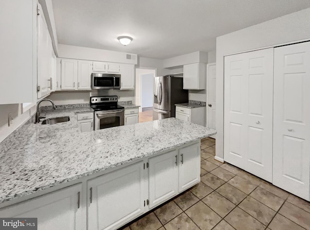 13109 Mica Ct, Silver Spring, MD 20904 - kitchen with stainless steel appliances, a sink, light tile patterned floors, light stone countertops, and a peninsula