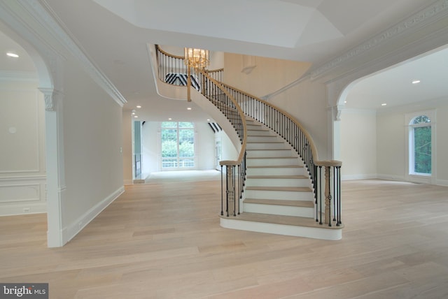 10124 Wendover Dr, Vienna, VA 22181 - stairway with arched walkways, a chandelier, wood finished floors, healthy amount of natural light, and crown molding