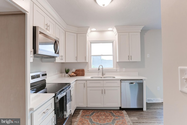 1667 Beech Ln, Hanover, PA 17331 - kitchen with stainless steel appliances, a sink, wood finished floors, white cabinetry, and recessed lighting
