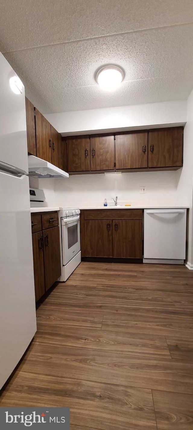 178 Woodstream Building 5, Norristown, PA 19403 - kitchen with white appliances, under cabinet range hood, dark wood finished floors, light countertops, and dark brown cabinetry