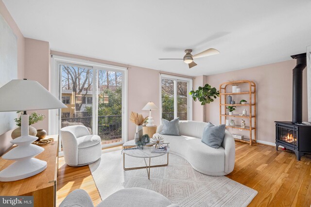 320 G St SW, Washington, DC 20024 - living room with a wood stove, light wood finished floors, ceiling fan, and plenty of natural light