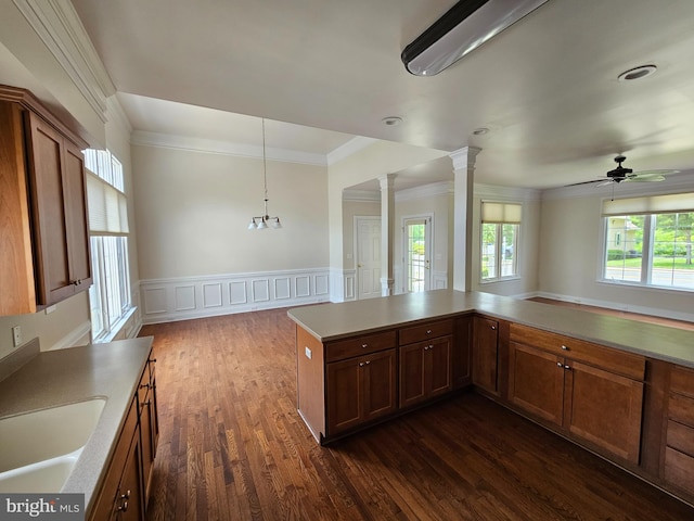 204 Turtle Cv Unit 116, Laurel, DE 19956 - kitchen featuring crown molding, ornate columns, dark wood-style floors, a ceiling fan, and a wainscoted wall