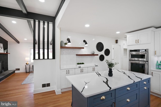 3900 Millcreek Dr, Annandale, VA 22003 - kitchen featuring double oven, open shelves, white cabinets, beam ceiling, and light wood-style floors